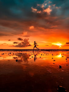 silhouette photo of person running near seashore