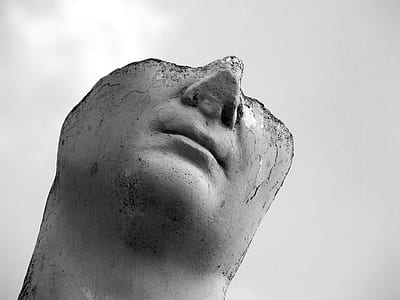 grayscale photo of beheaded statue