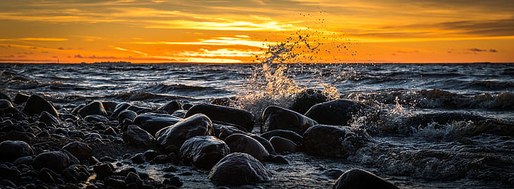 waves splashing through rocks during golden hour