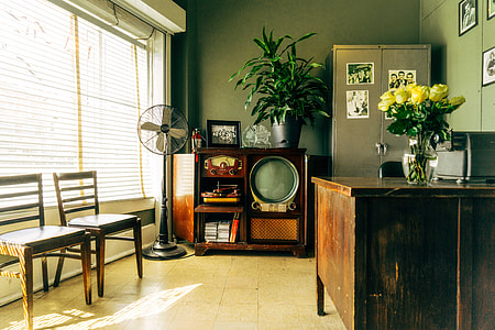 classic television beside pedestal fan inside an office