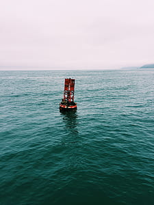 red buoy on bodies of water
