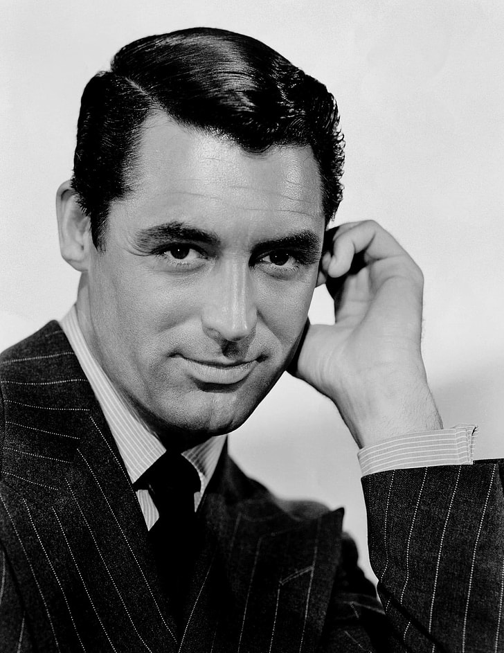 man wearing pinstripe suit with hand near left hand