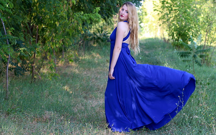 woman wearing blue halterneck sleeveless maxi dress outdoors