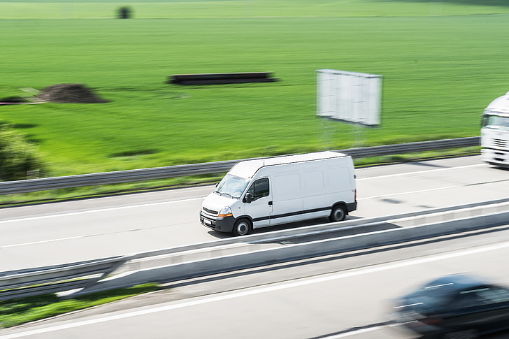 White Delivery Van in Motion Driving on Highway