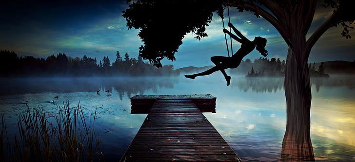 silhouette of a woman riding on swing at night