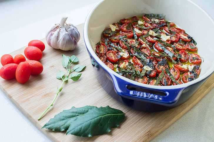 confit tomatoes and ingredients, cherry tomatoes, bay leaves, garlic and basil
