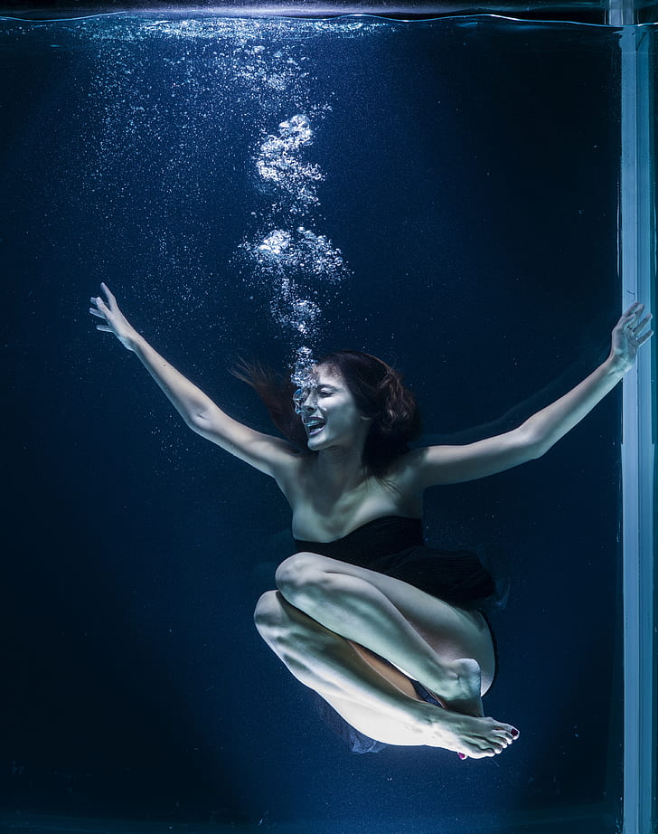woman wearing black bodysuit diving on water