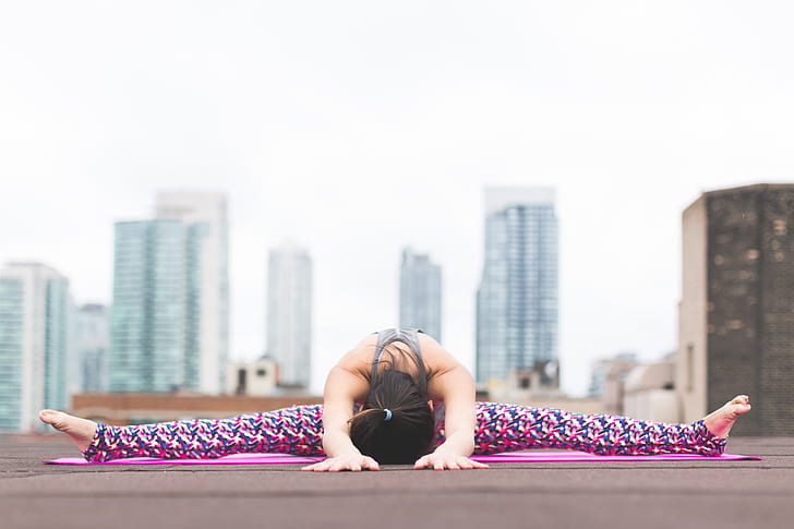 woman doing yoga with buildings on the background