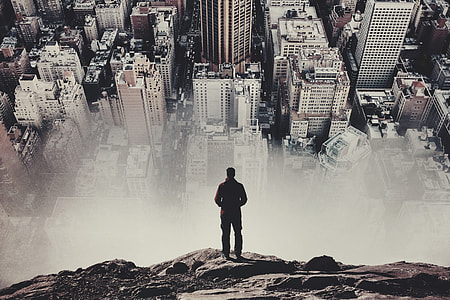 man standing overlook a city at daytime