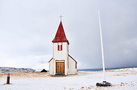 red and white church in middle of white land under gray clouds