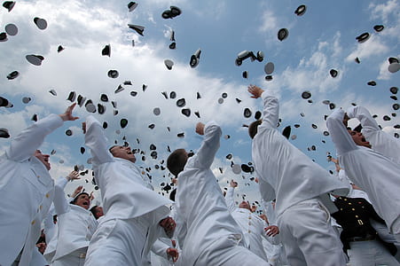 group of men tossing military hats