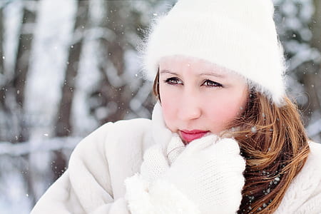 women in white beanie cap and coat portrait photography on snow terrain