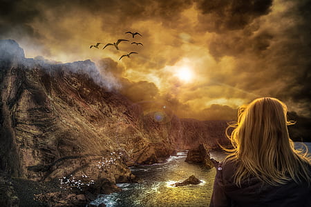 blonde haired woman with black shirt facing brown mountain during sunrise