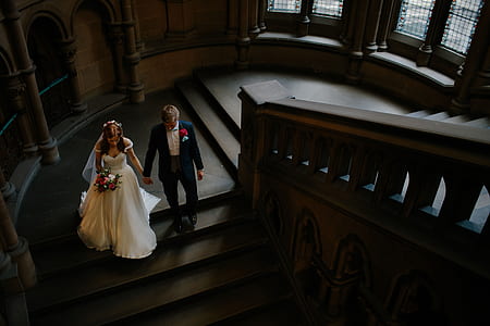 wedding couple walking on stairs holding hands