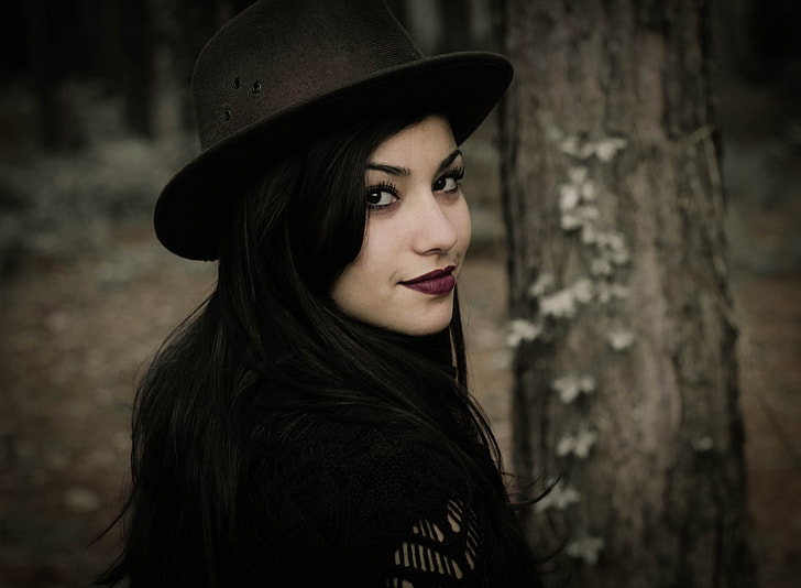 woman wearing black hat staring and smiling at the camera