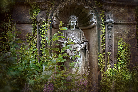 religious statue between green leaf plant