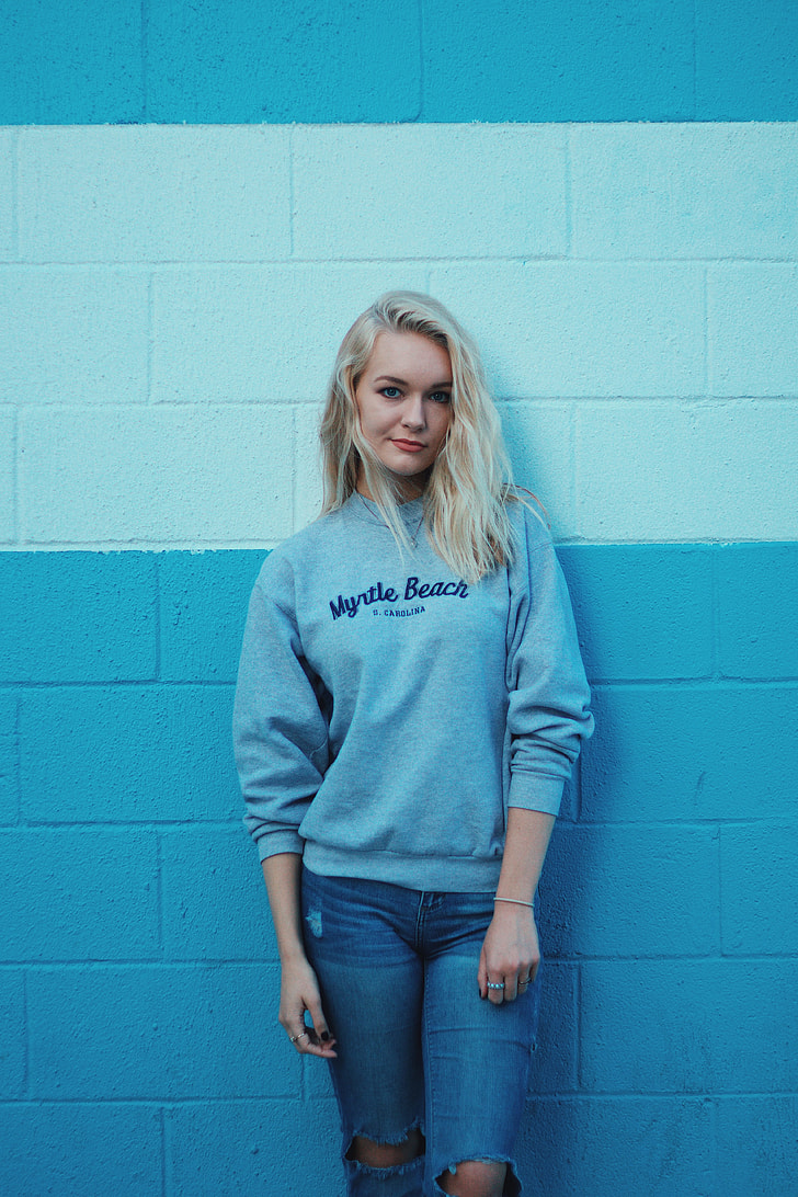woman wearing gray Myrtle Beach sweater and blue distressed jeans