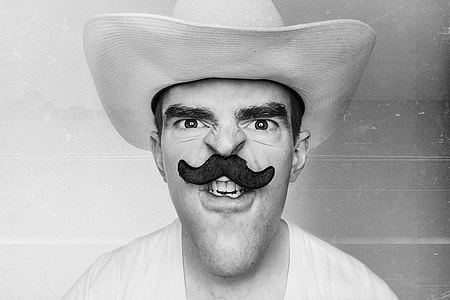 grayscale photography of man in cowboy hat with mustache