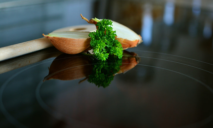 selective-focus photography of sliced onion and green parsley on black surface