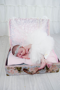 baby wearing white tutu skirt and silver alice band in a luggage photo session