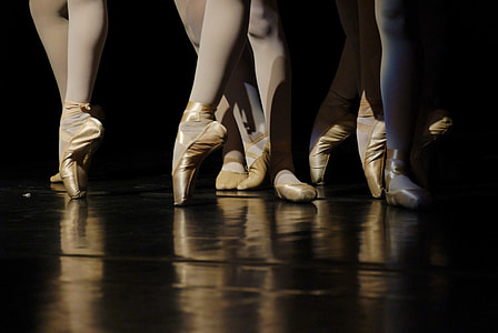 low angle photography of people in ballet suit and shoes