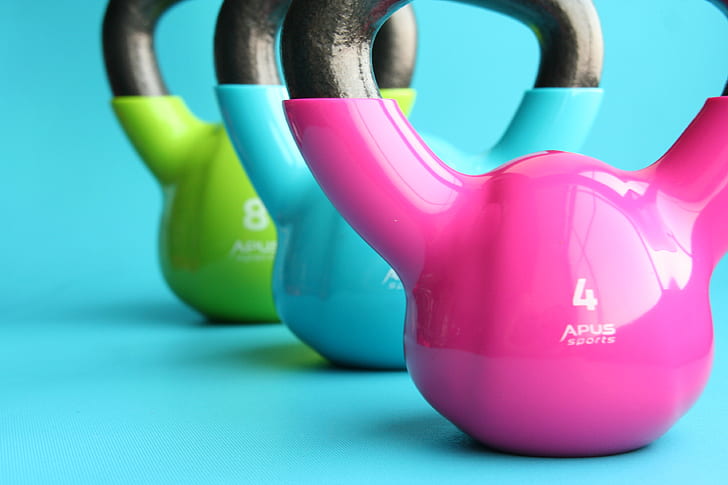 three pink , blue, and green kettle bells