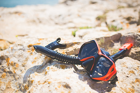 Snorkel and Diving Scuba Mask On a Rock Near The Sea