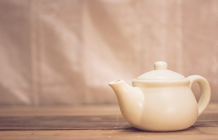 white ceramic teapot on brown surface