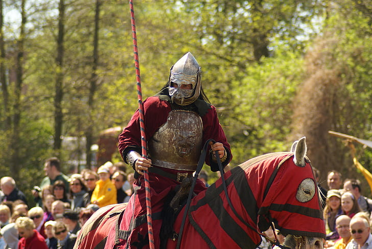 man in red and gray knight suit riding horse in red and black textile