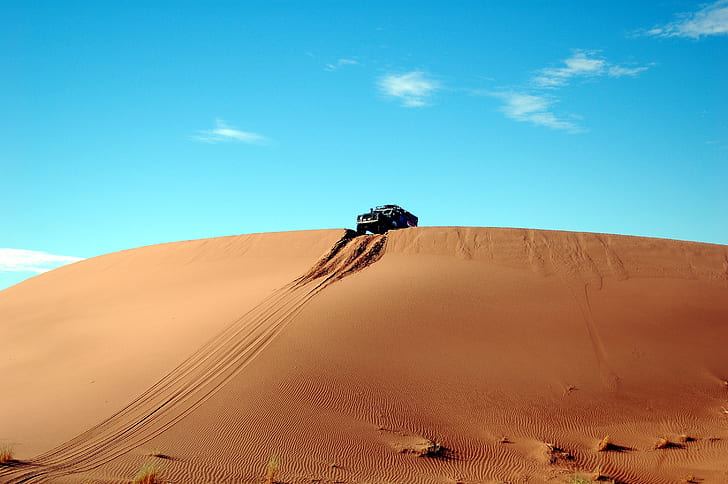 black vehicle riding on desert