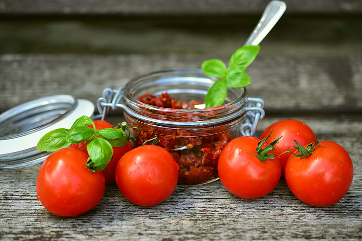 tomatoes and airtight jars with chili inside
