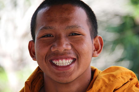 man wearing yellow jacket smiling on camera