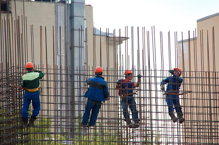 people hanging on grey metal scaffolding