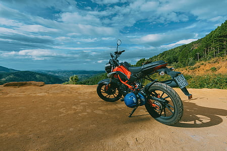 Photography of Orange and Black Sports Motorcycle Near a Cliff