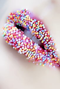 woman's lip with assorted-color candies