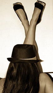 woman wearing brown fedora hat and black closed-toe shoes