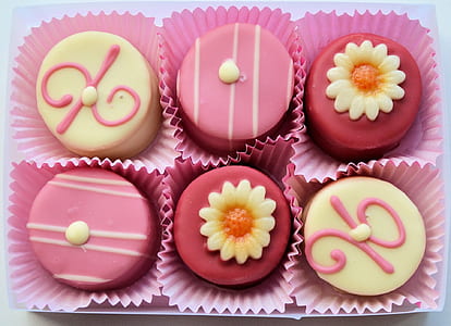 close-up photo of 6-pieces pink and beige-icing covered muffins