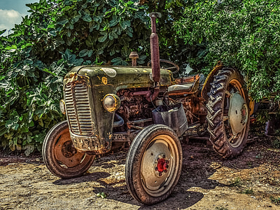 vintage brown and black tractor near green plants
