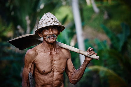 photography of man holding shovel