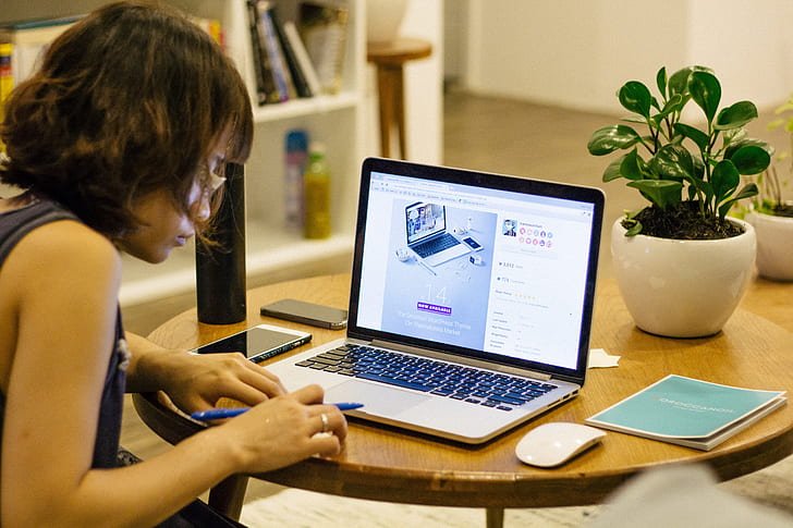 woman sitting in front of MacBook Pro