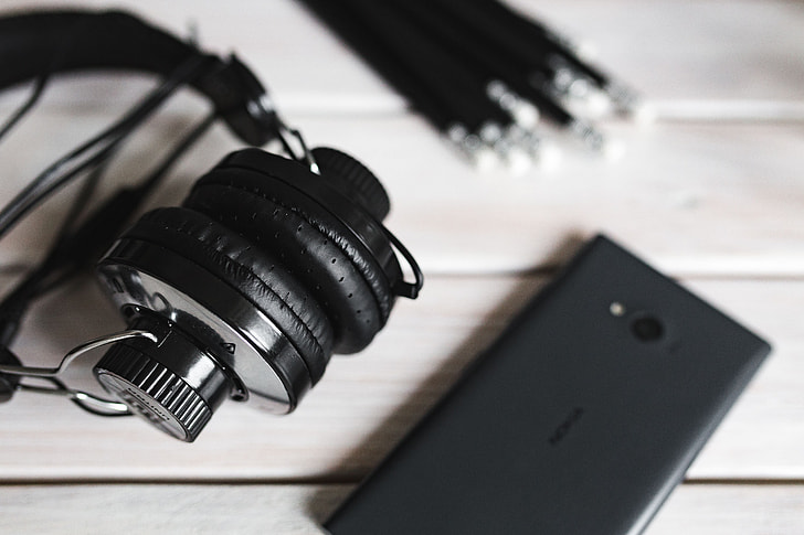 Black smartphone and headphones with various items