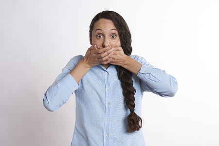 woman wearing white dress shirt covering her mouth