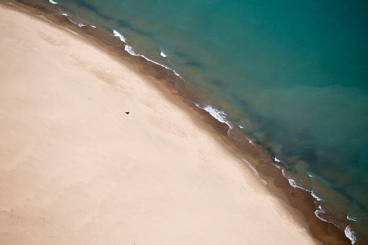 aerial photography of brown coast beside body of water