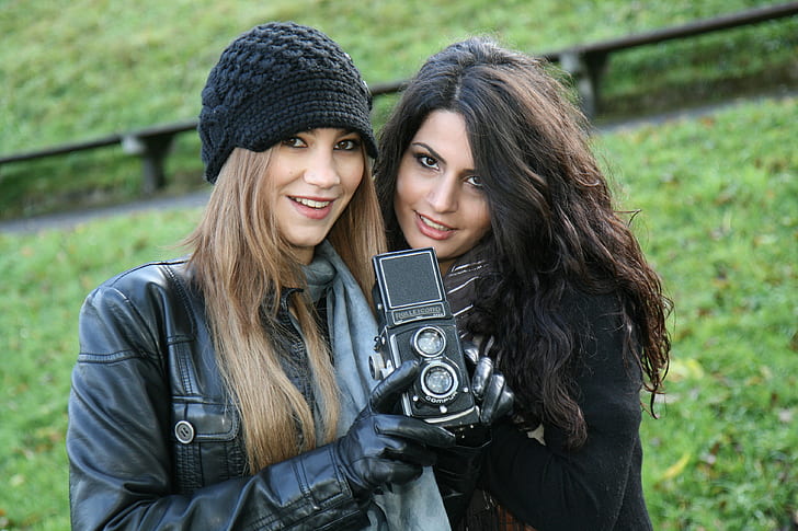 photography of two women holding camera