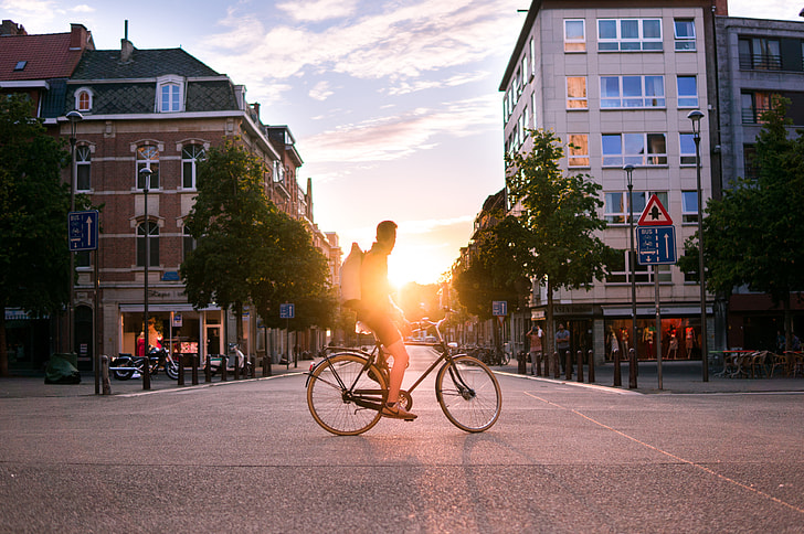 man on bicycle on the road during sunset