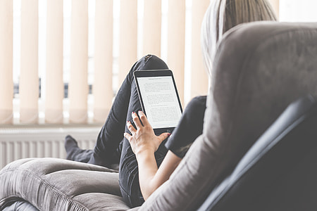 Young Woman Reading eBooks on Her iPad Tablet