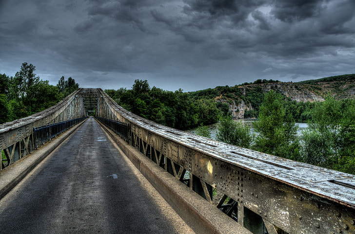 landscape photography of gray and white bridge under dark clouds