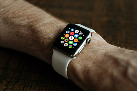 person wearing silver aluminum case Apple Watch with white sport band