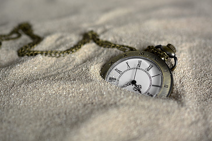 shallow focus photography of pocket watch on white sands