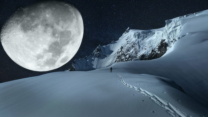 person walking on snow under moon on dark sky